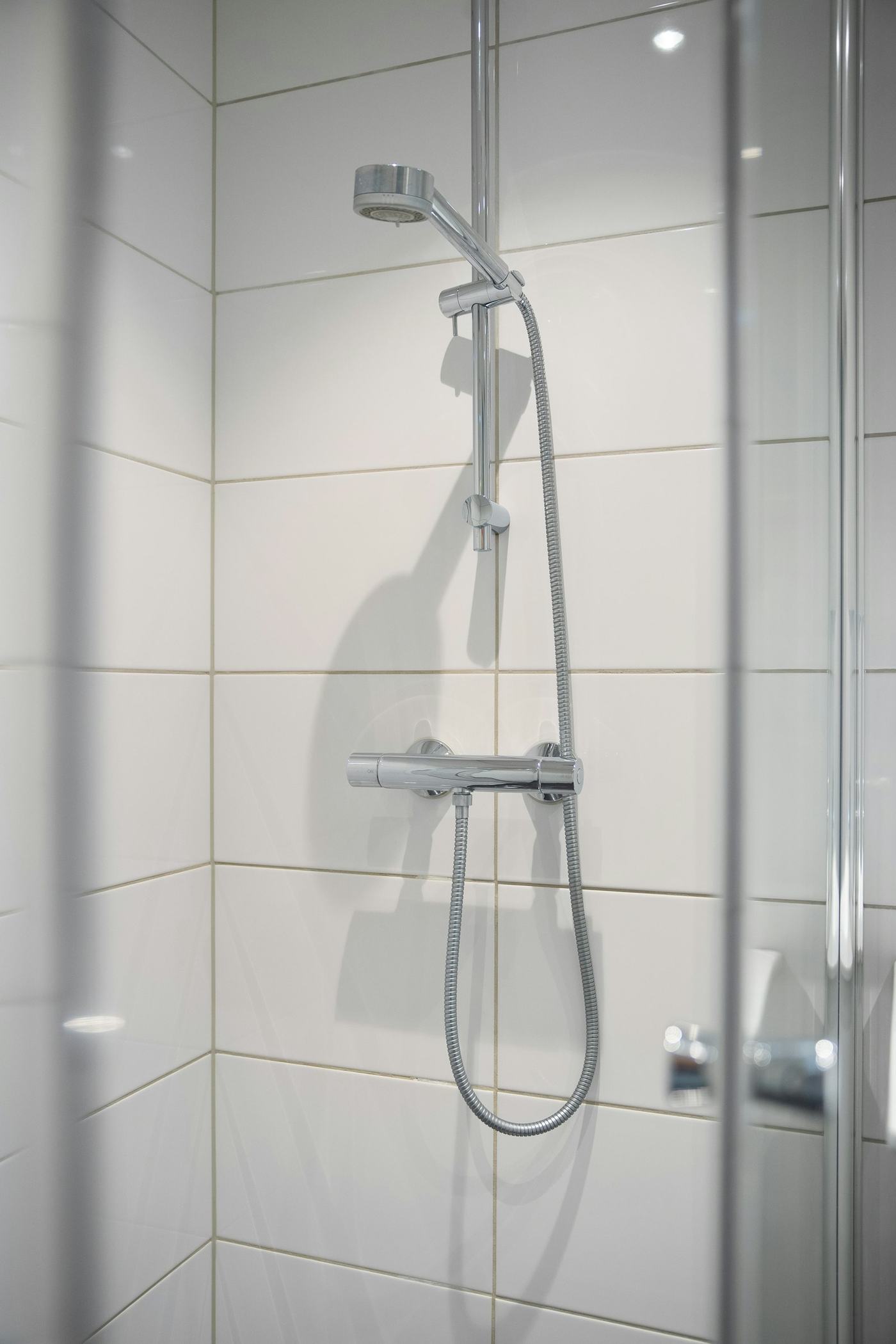 White tiled shower with glass door