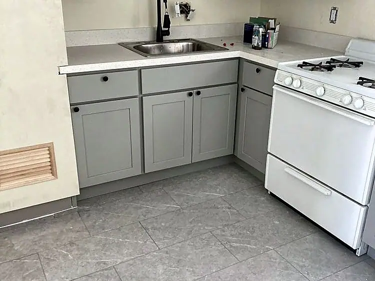 Small kitchen with new gray shaker cabinets and a white range