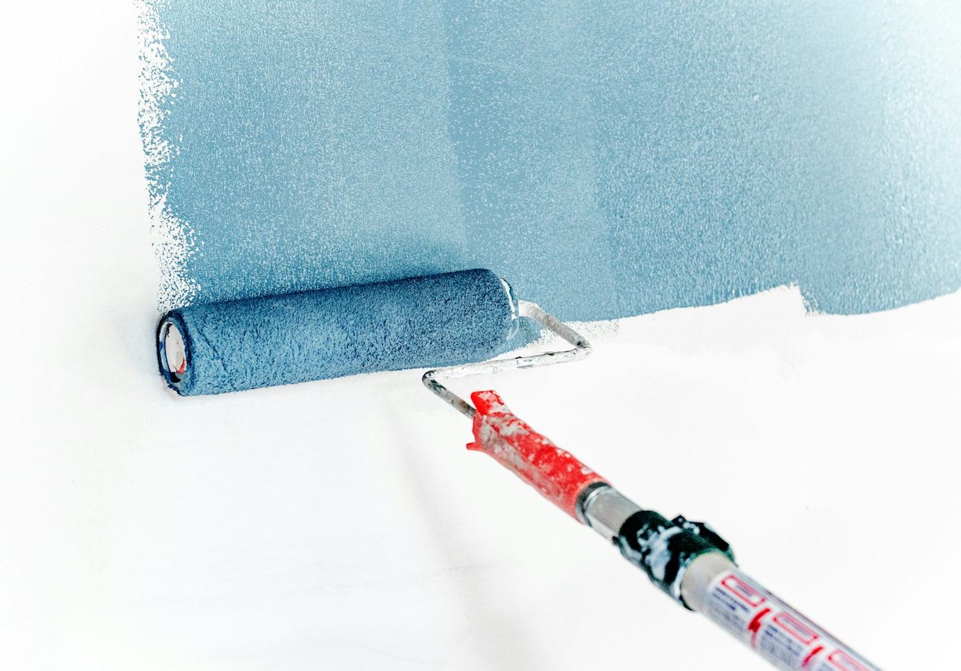 Roller applying blue paint
