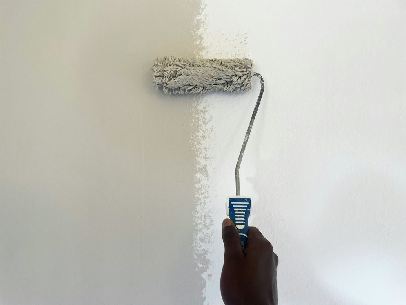 Roller painting a wall white
